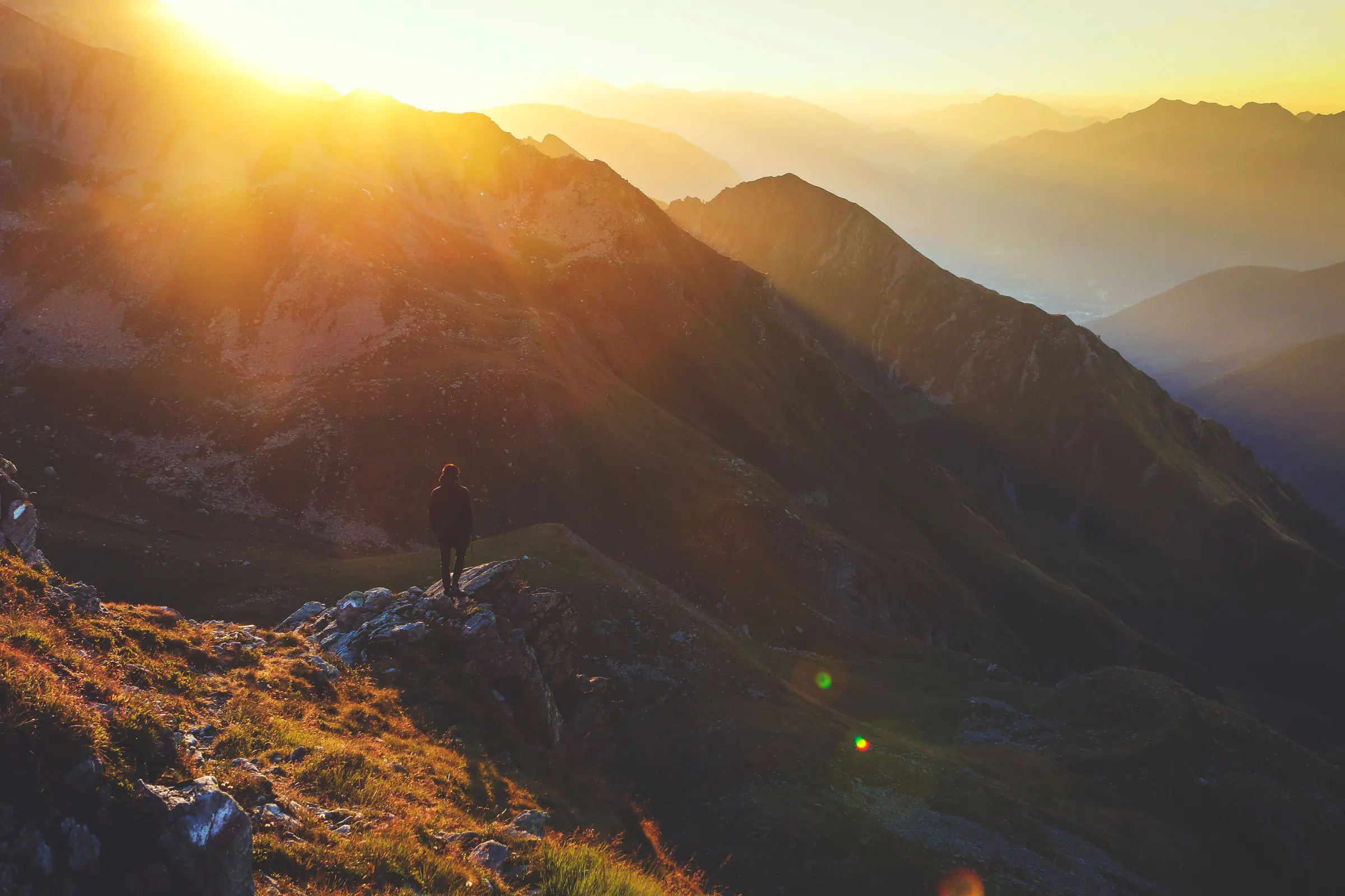Sonnenstrahlen fallen über Bergrücken und formen die Landschaft.